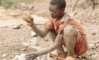 A child in Uganda crushes a stone at a quarry. More children have resorted to getting work due to the effects of the coronavirus pandemic, a new report reveals.