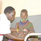 Joyce Alok (L) the nursing officer at Nakapelimoru HC III,<br />examining Epuri Oyelle a mother that came from Kenya to<br />deliver in Uganda